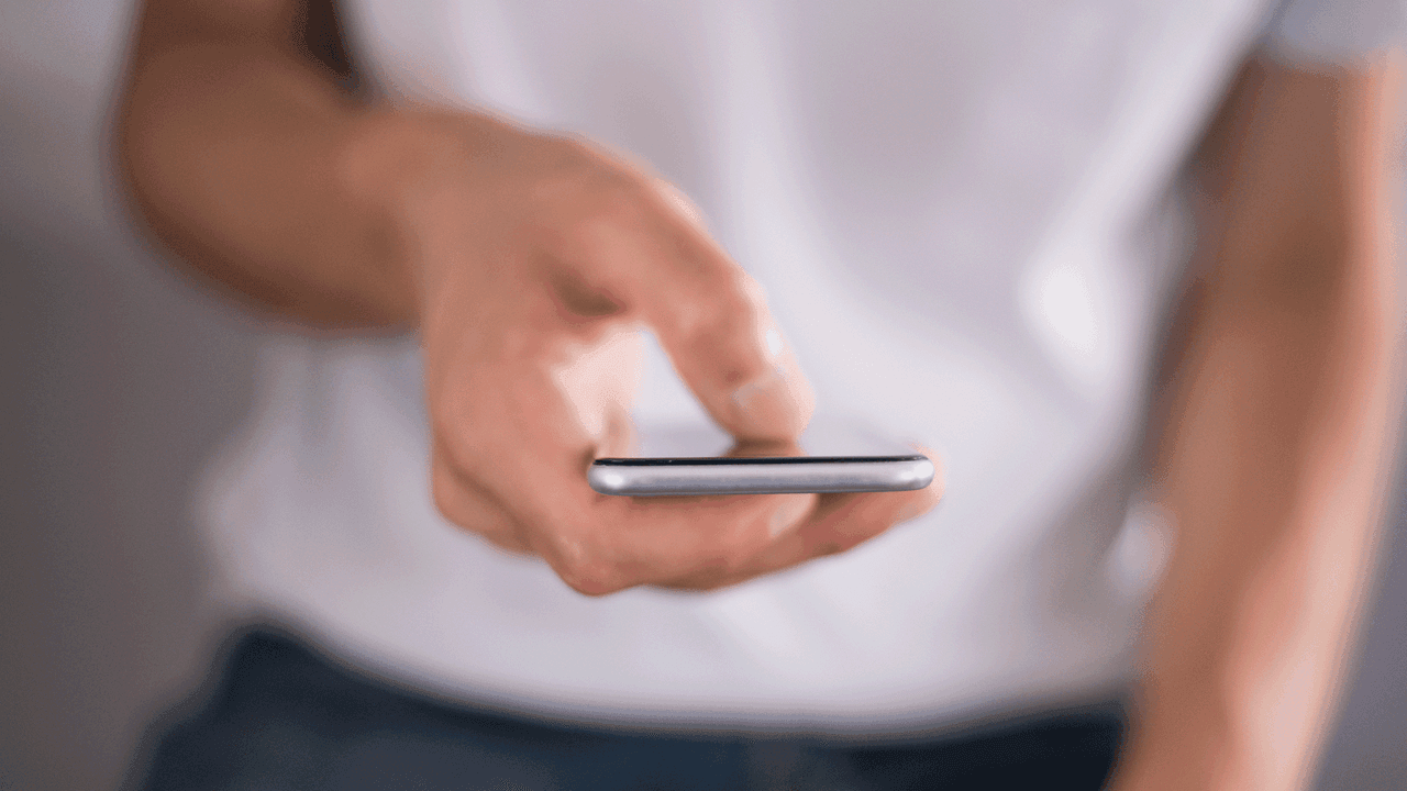 Kuvituskuvassa henkilö selaa gsm-puhelinta.