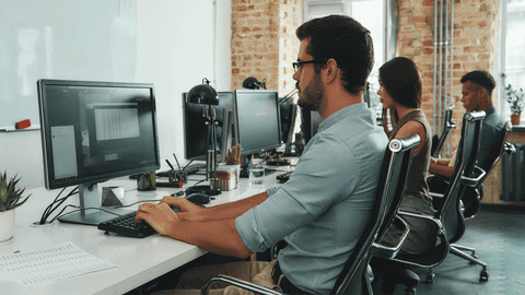 ihmisiä työskentelemässä tietokoneilla