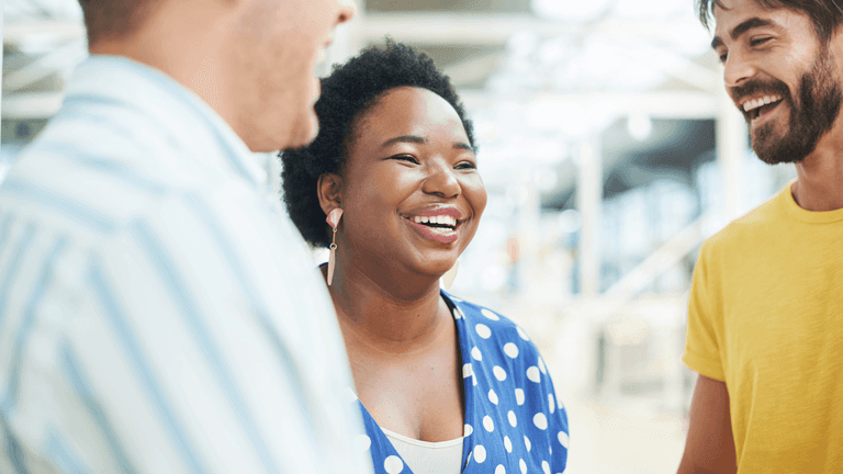 Iloinen monikulttuurinen porukka toimistolla